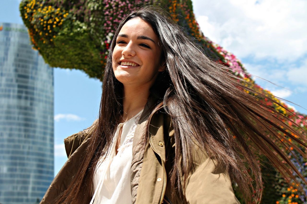 portrait, looking at camera, young adult, young women, front view, person, smiling, lifestyles, casual clothing, leisure activity, low angle view, happiness, toothy smile, religion, spirituality, day, long hair