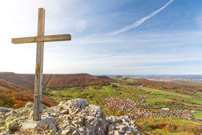 Cross on landscape against sky