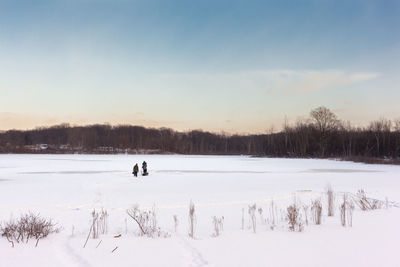 Scenic view of frozen landscape against sky during winter