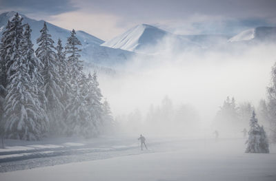 Panoramic view of snow covered mountains against sky