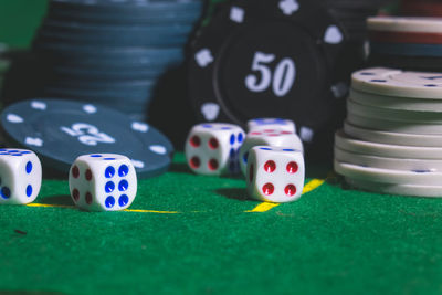 Close-up of gambling chips with dices on table in casino