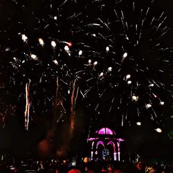 Low angle view of firework display at night