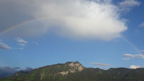 Low angle view of rainbow over mountains against sky