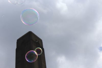 Low angle view of bubbles against blue in sky in london. 