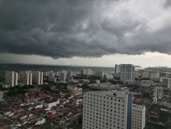 Modern buildings in city against storm clouds