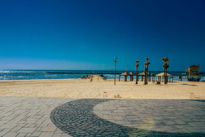 Scenic view of beach against clear blue sky