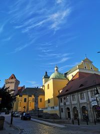 Street amidst buildings against blue sky