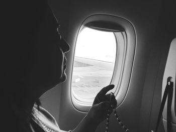 Woman holding necklace in airplane