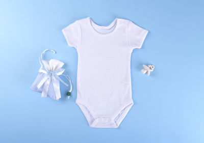 White baby shirt bodysuit on a blue background, for boys. mock up for design and placement of logos