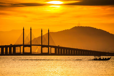 View of bridge over river at sunset