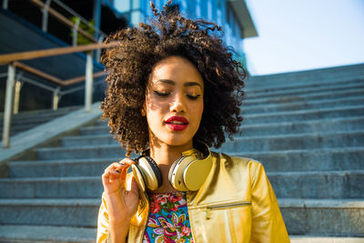 Fashionable young woman with curly hair in city