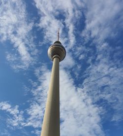 Low angle view of communications tower against cloudy sky