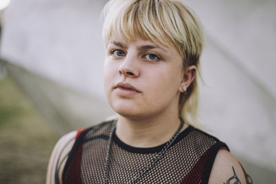 Portrait of happy young non-binary person with short blond hair