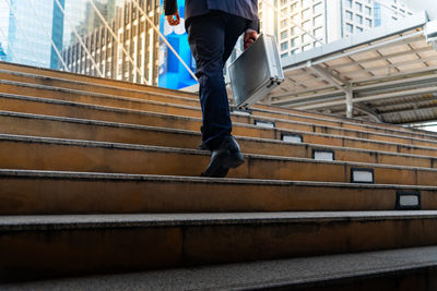 Low section of man standing on staircase