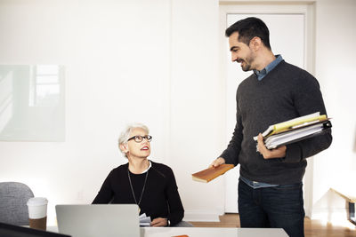 Businessman talking on senior colleague during meeting in office