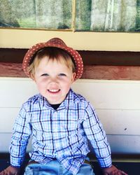 Portrait of smiling boy sitting at home