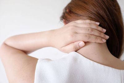 Rear view of woman lying on white background