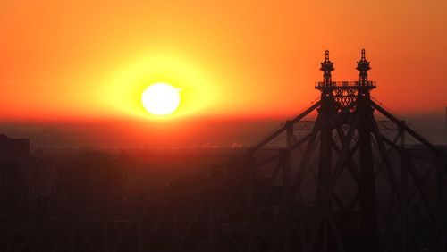 Silhouette of iron bridge against sky during sunset