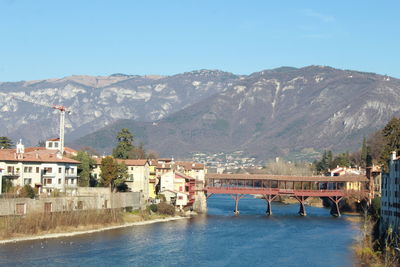 Bridge over river with mountain range in background