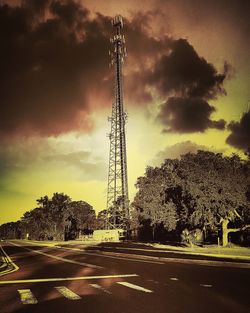 Electricity pylon against cloudy sky