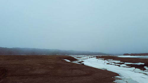 Scenic view of snowy field against clear sky