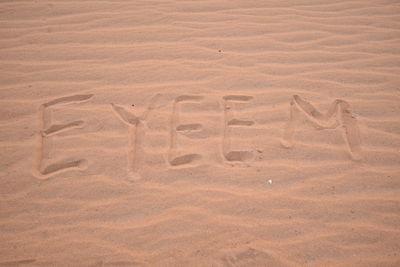 High angle view of text on sand at beach