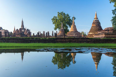 Reflection of temple on building against sky