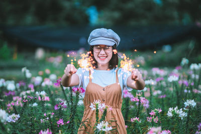 Portrait of a smiling young woman on purple flowering plants