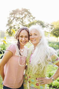 Portrait of adult daughter and mother in garden