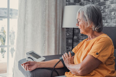Side view of young woman using laptop at home