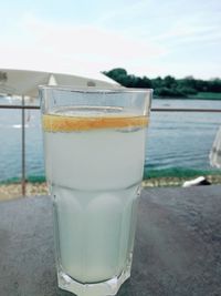 Close-up of drink on beach against sky