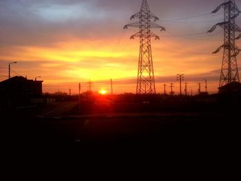 Silhouette electricity pylon against sky during sunset