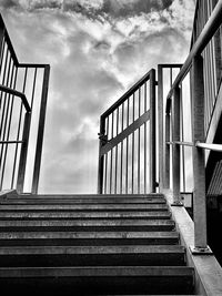 Low angle view of staircase amidst buildings in city against sky