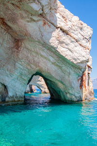 Rock formation in sea against sky