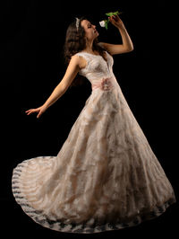 Midsection of woman dancing against black background