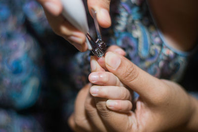 Cropped image of mother cutting fingernails of child