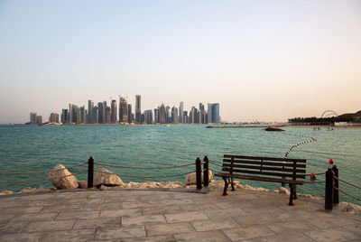 Scenic view of sea and buildings against clear sky