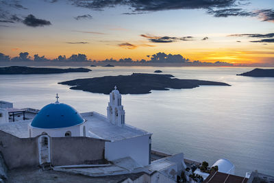 Scenic view of sea and buildings against sky during sunset