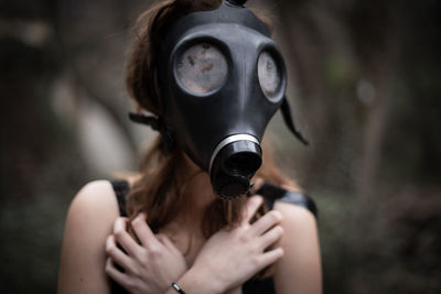 Woman wearing gas mask while covering chest