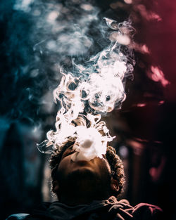 Close-up low angle view of man smoking at night