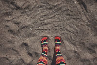 Low section of person standing on sand