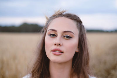 Beautiful woman on wheat field. young female with makeup beauty portrait outdoors. ukrainian