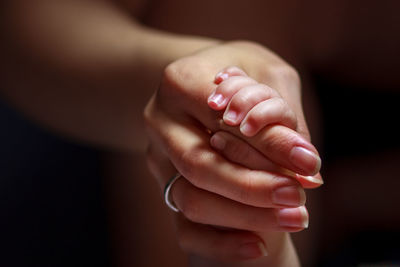 Cropped image of mother and child with holding hands