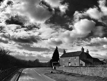 Empty road against cloudy sky
