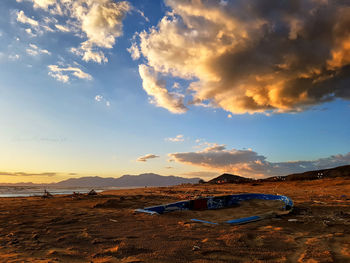 Scenic view of beach against sky at sunset