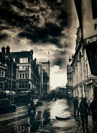 Buildings in city against cloudy sky