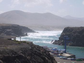 Scenic view of sea and mountains against sky