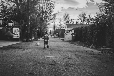 Rear view of woman walking on road