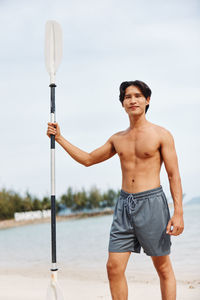 Portrait of young man standing against sky