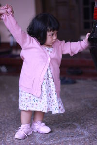 Full length of cute girl standing pink flower